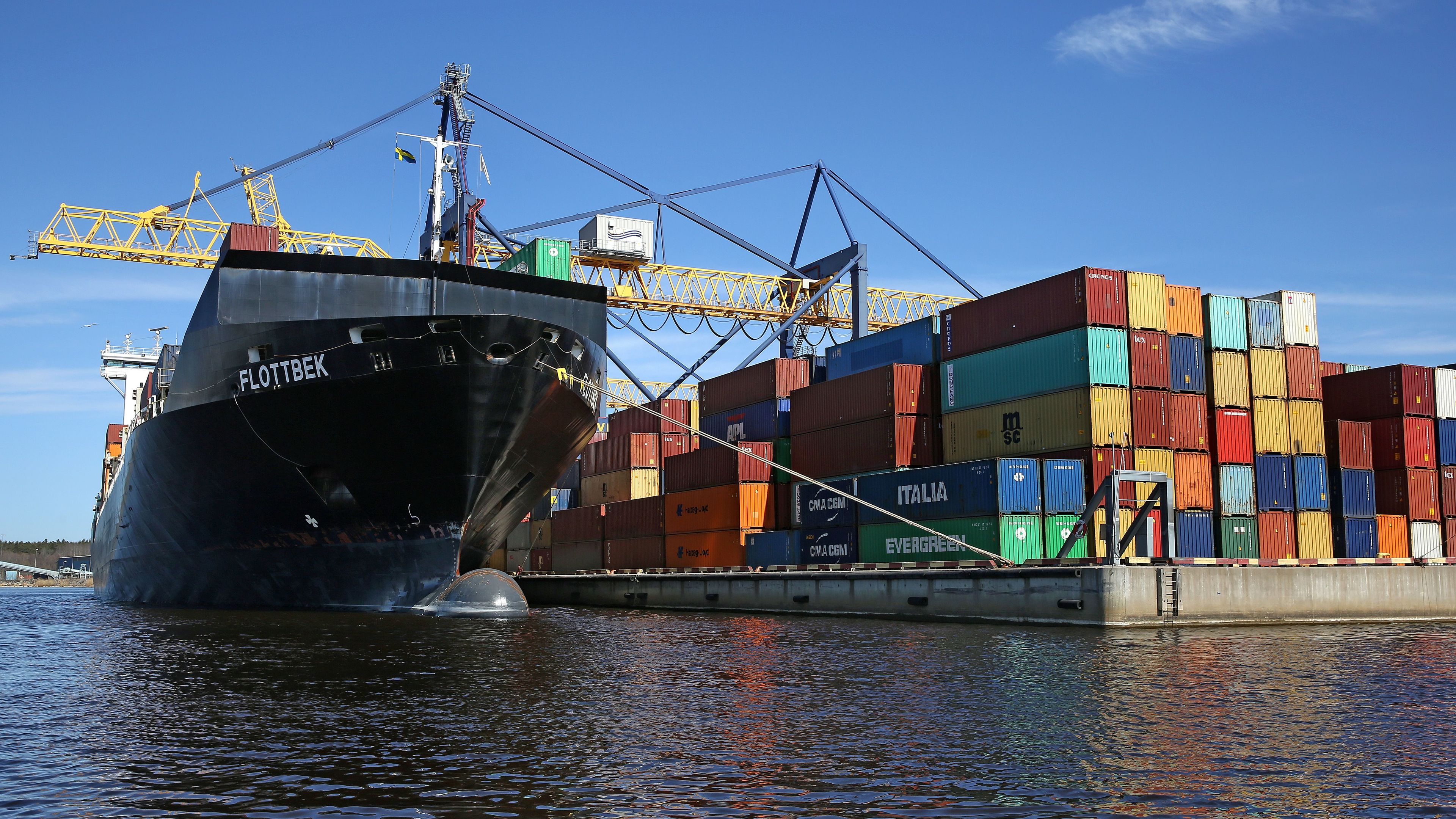 Containerfartyg i hamn under lastning av containrar.