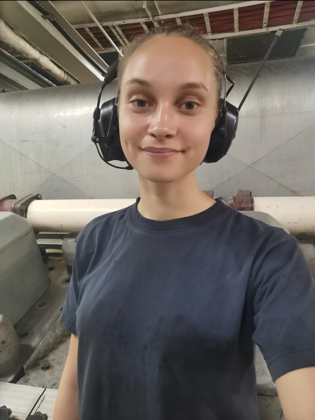 Maskinpersonalen Amanda nere i ett maskinrum med hörselkåpor.