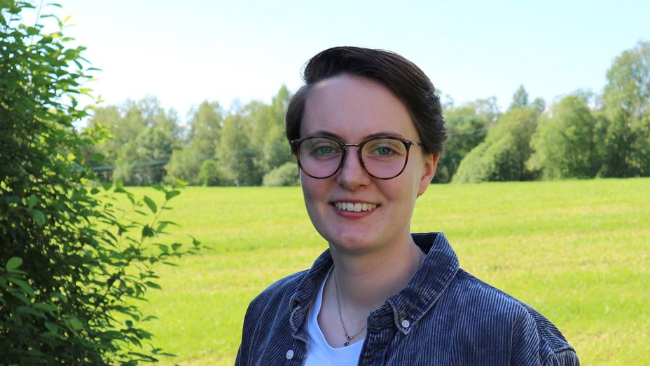 Studenten Cajsa framför ett rapsfält.