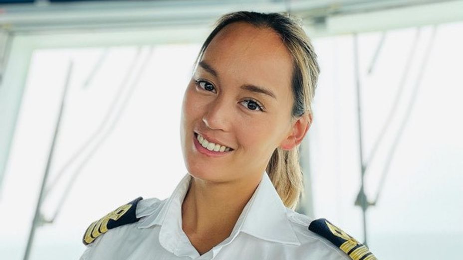 En porträttbild på överstyrman Ida i uniform på bryggan.