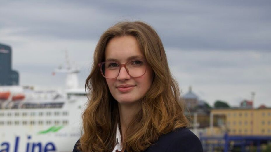 Porträttbild på studenten Karin framöver Göta älv med Stena Lines fartyg i bakgrunden