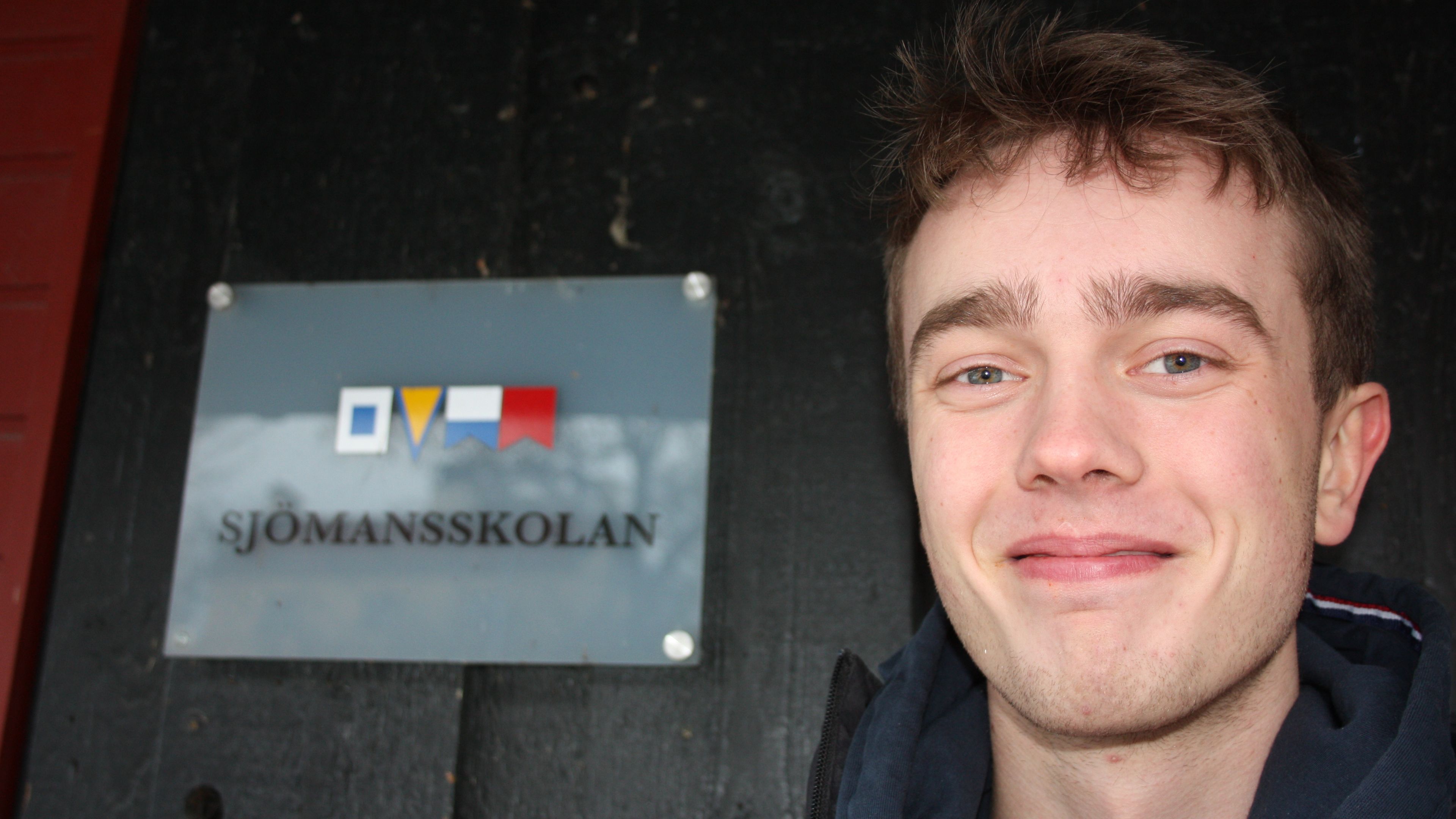 Eleven Emil bredvid skylten till Sjömansskolan i Stockholm.