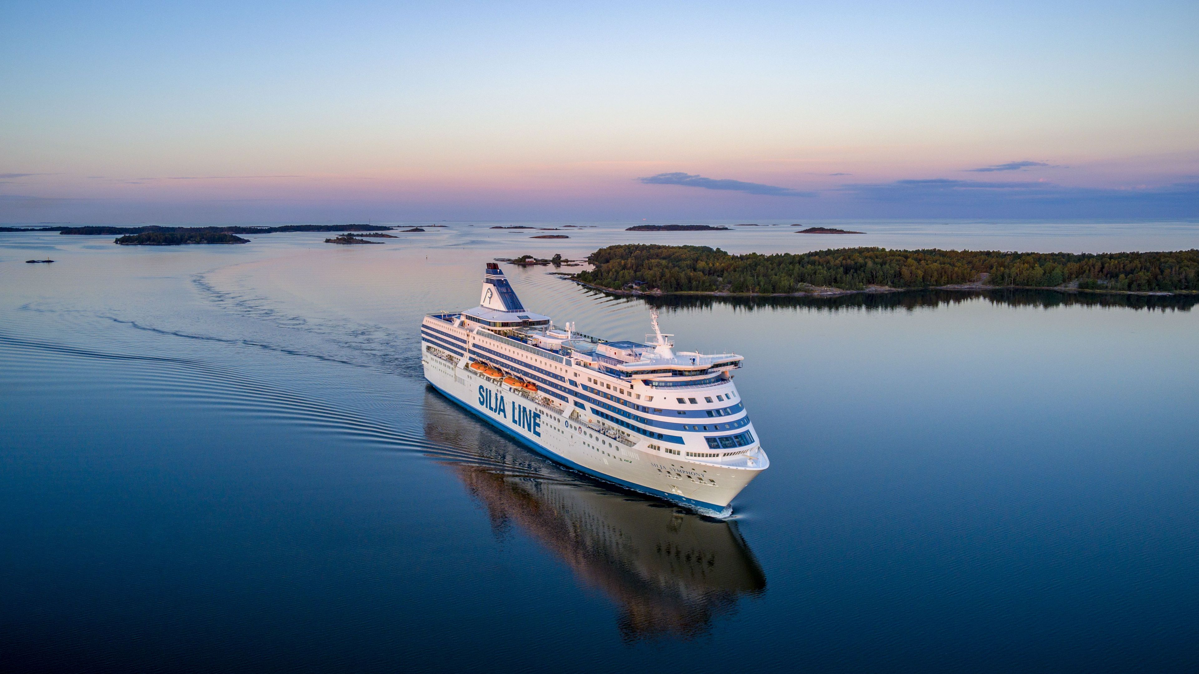 Silja Symphony till sjöss i en skärgård med öar i bakgrunden.
