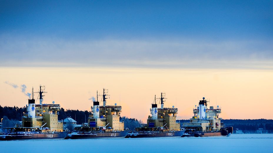 Isbrytare på rad vid kaj i hamn.